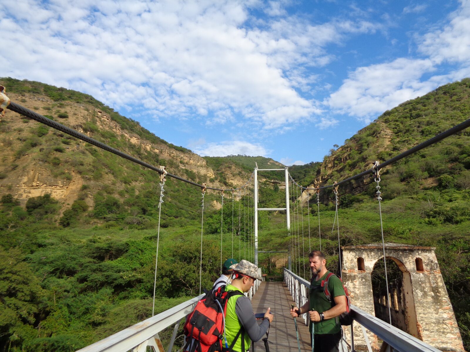 Caminantes cruzando un puente colgante en el Camino de Lenguerke y Yariguíes